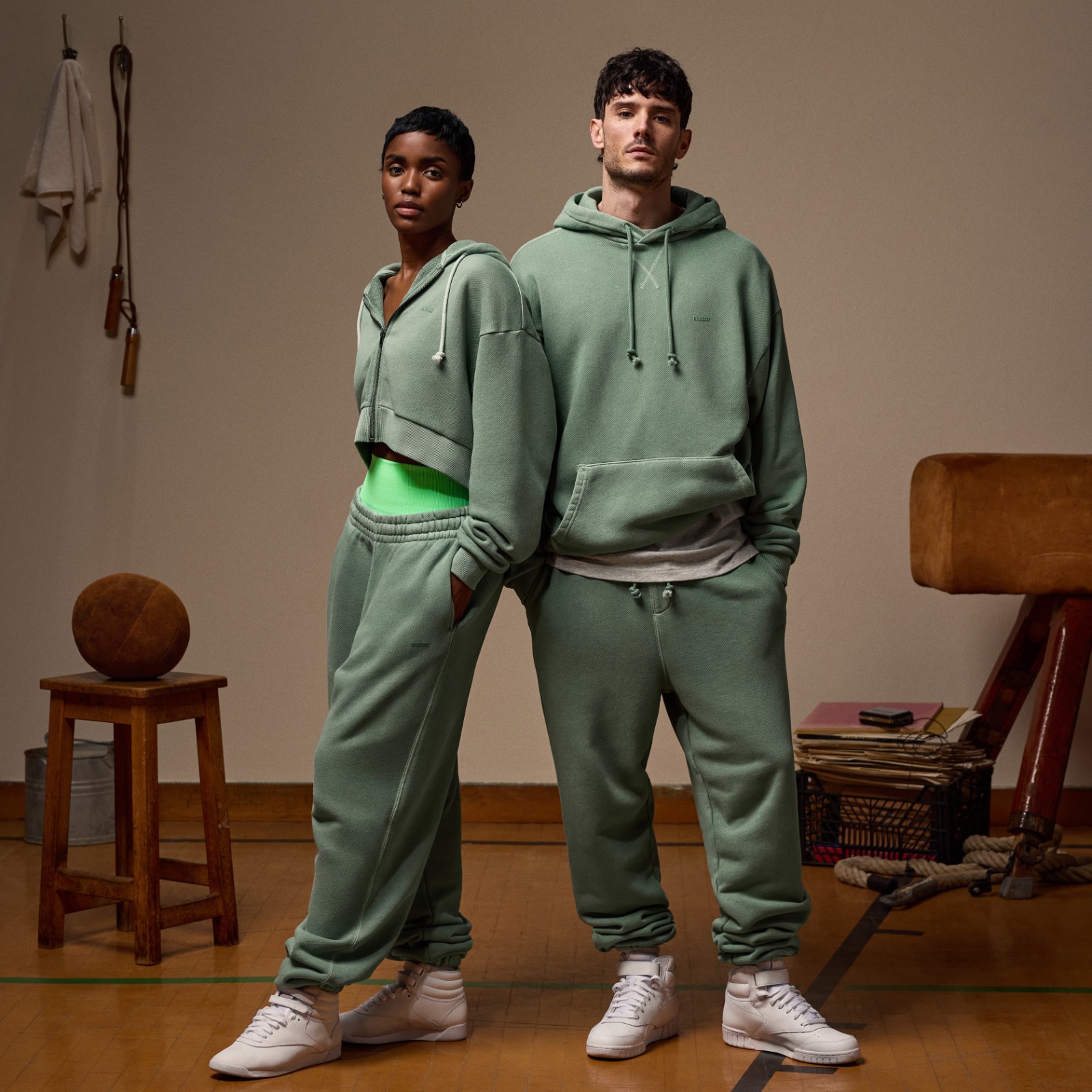 Forest-green premium athleisure garments on natural stone